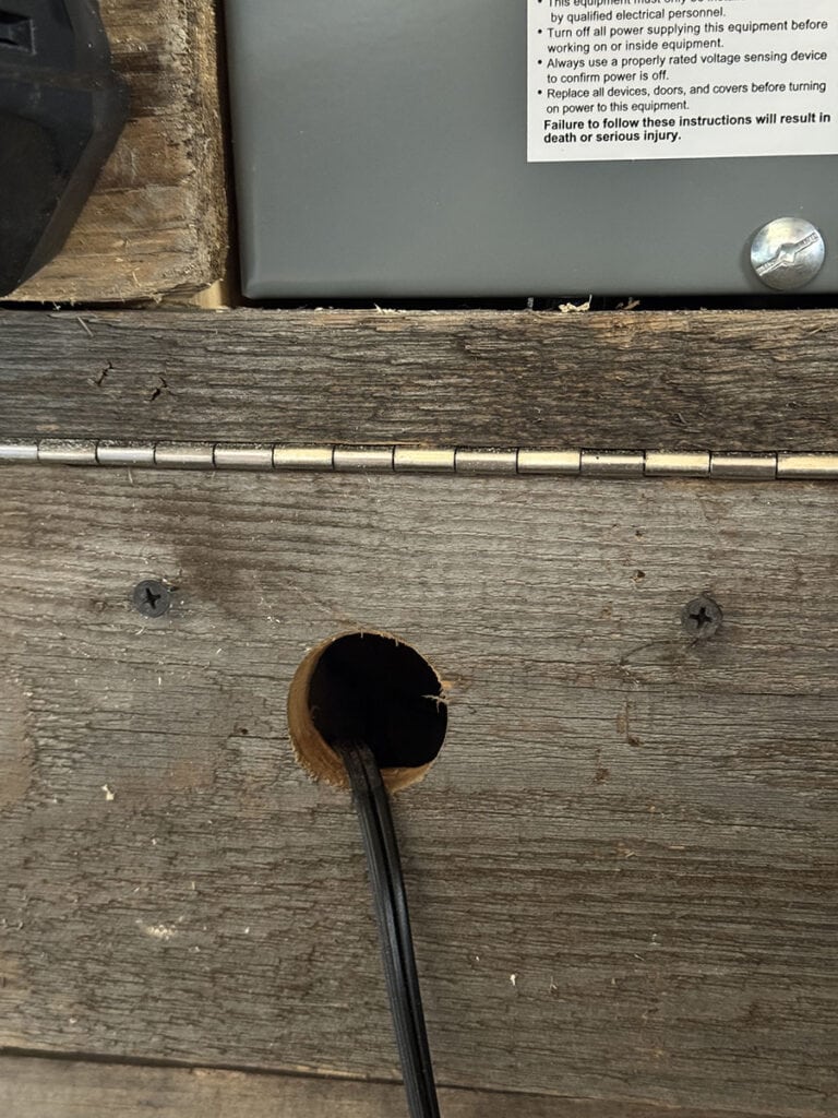 Drilled hole for cable management located behind the battery charger location.